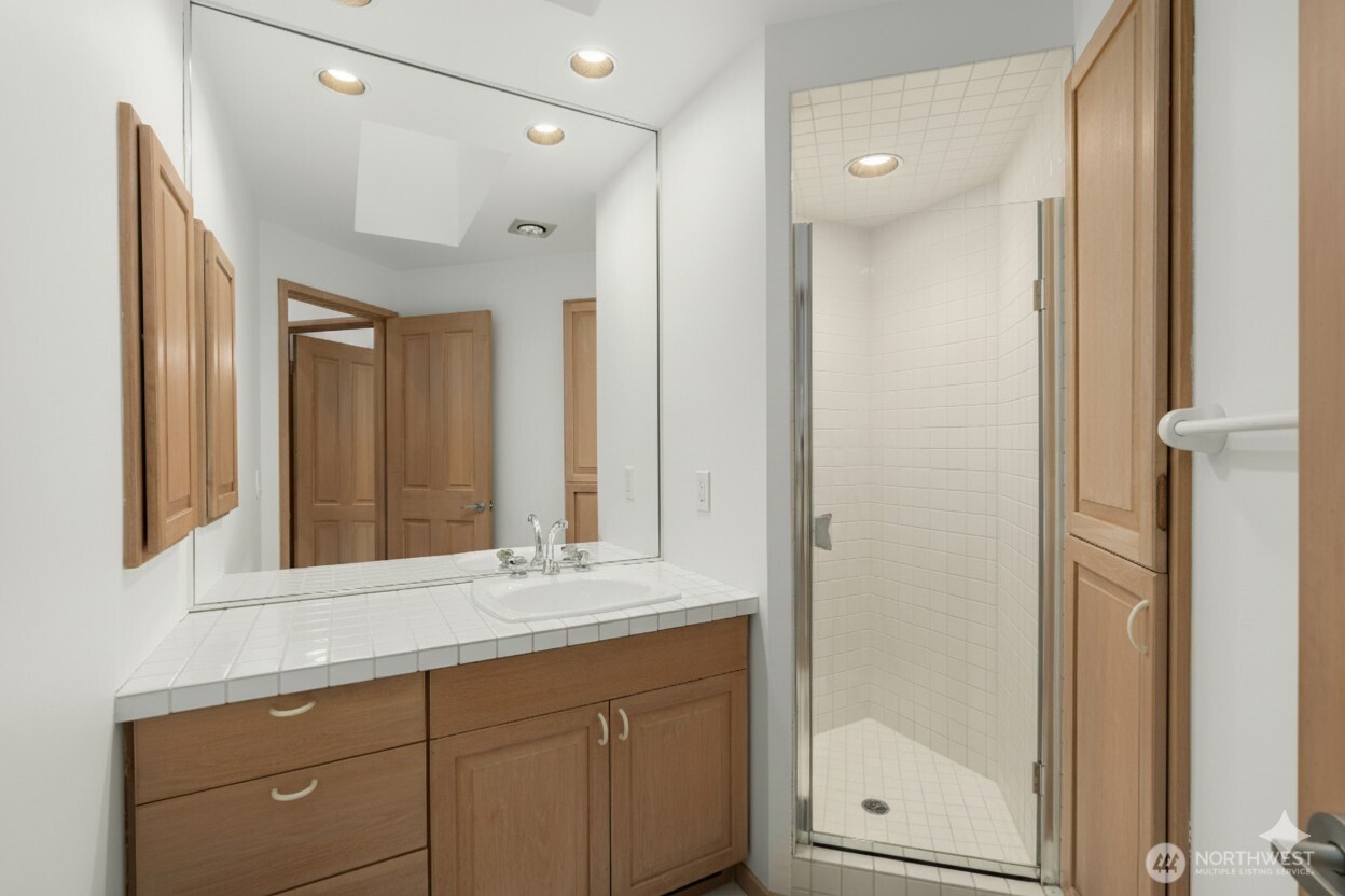 8428 North Mercer Way Mercer Island, WA 98040 - Photo 27 of 40 a bathroom with a shower sink and mirror