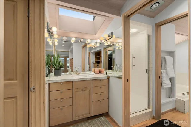 a bathroom with a double vanity sink and mirror with shower