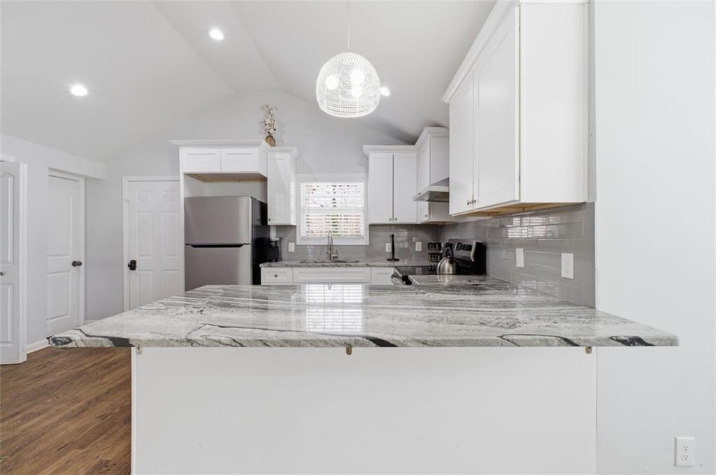 85 Meldon Avenue Southeast Atlanta, GA 30315 - Photo 28 of 39 a kitchen with kitchen island granite countertop a refrigerator a stove a sink and white cabinets