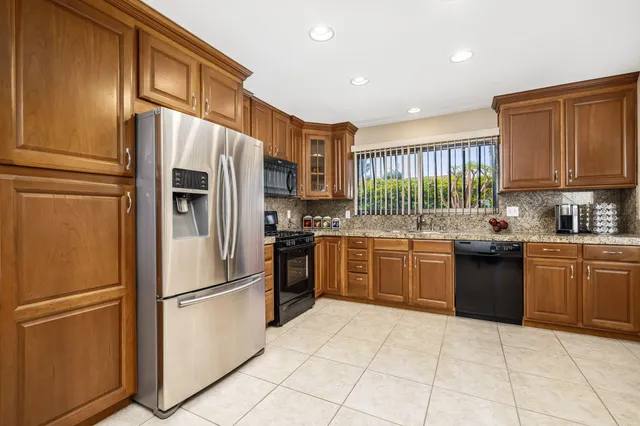 a kitchen with stainless steel appliances granite countertop a refrigerator sink and stove