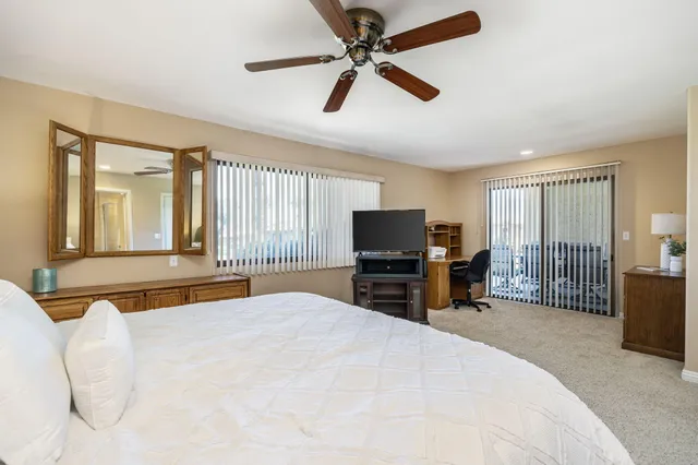 a bedroom with a bed a television and a large window