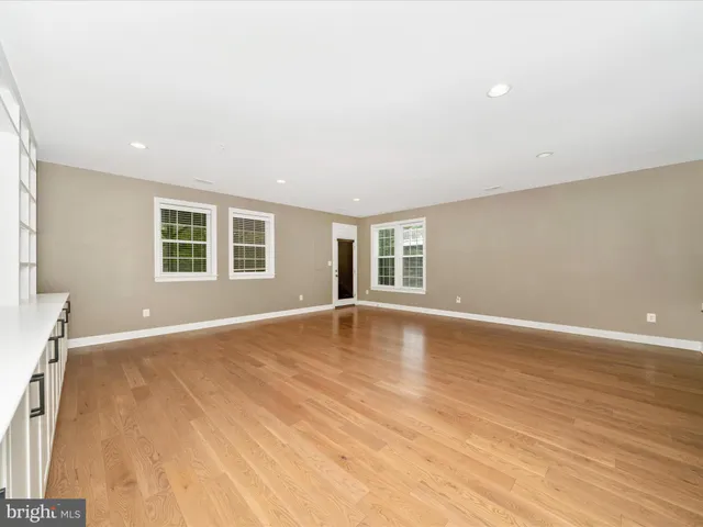 a kitchen with stainless steel appliances granite countertop a stove a refrigerator a sink a dining table and chairs with wooden floor