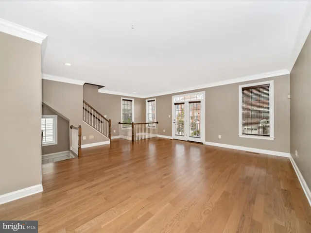 a view of a big room with wooden floor and windows