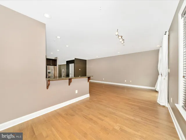 a view of a room with wooden floor and ceiling fan