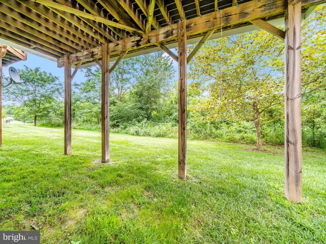 a view of empty room with wooden floor and window