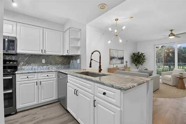 a kitchen with granite countertop a sink and white cabinets