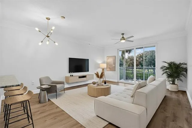 a living room with furniture a large window and a flat screen tv