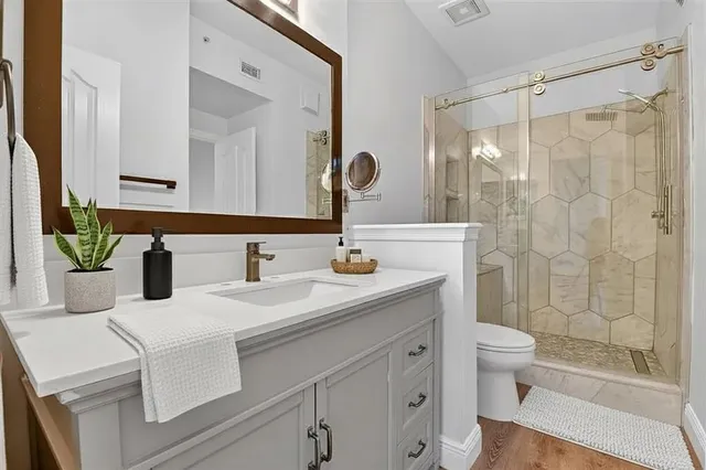 a bathroom with a granite countertop sink a toilet and shower