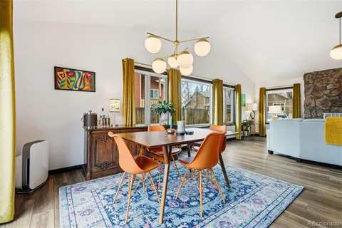a dining room with wooden floor and a chandelier