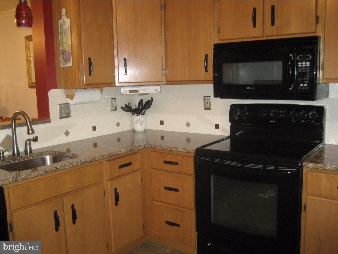 14-4 Cranberry Ridge, Unit 3 Reading, PA 19606 - Photo 6 of 24 a kitchen with granite countertop a sink stove and microwave