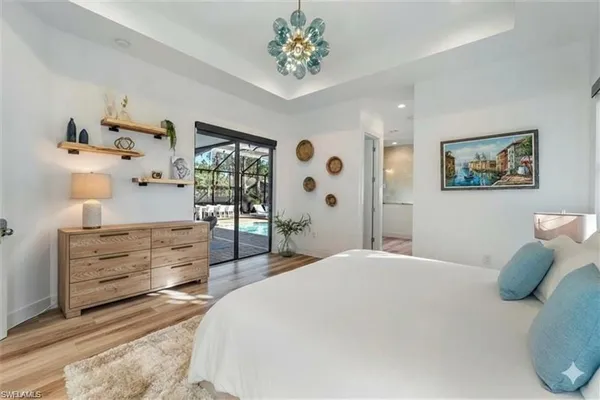 a bedroom with a bed and a chandelier