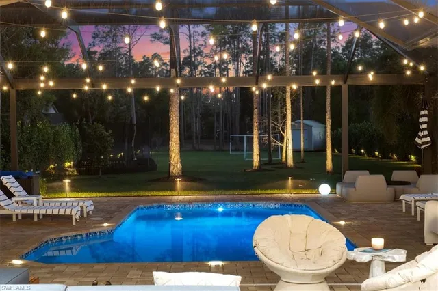 a view of a swimming pool with a patio and a yard