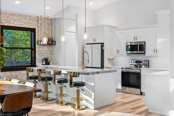 a kitchen with appliances a sink and cabinets