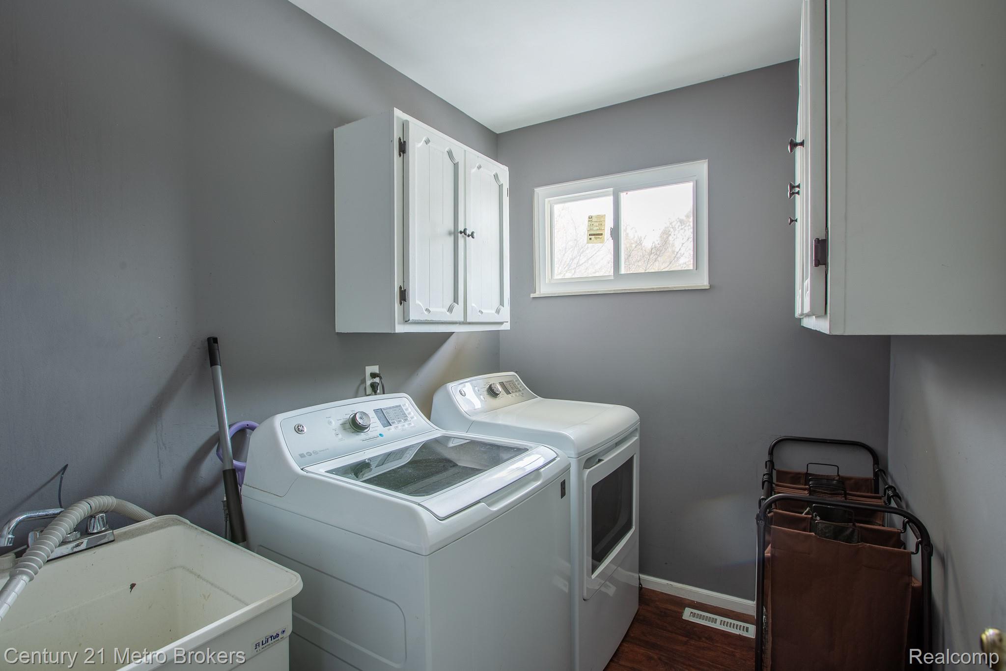 6101 Belsay Road Grand Blanc, MI 48439 - Photo 21 of 28 Laundry area featuring cabinet space, washer and dryer, and dark wood finished floors