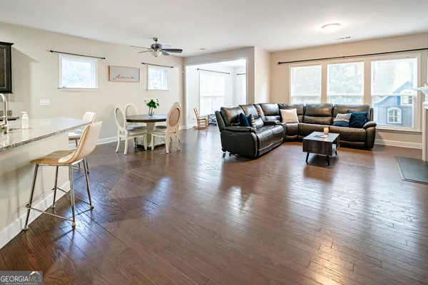 a living room with furniture floor to ceiling window and wooden floor