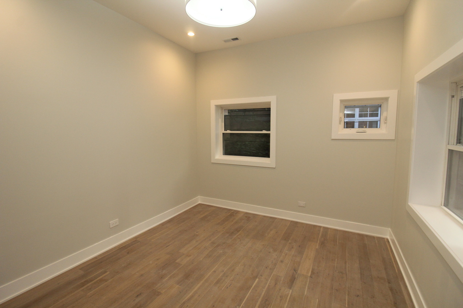 64 East Cedar Street, Unit 2R Chicago, IL 60611 - Photo 14 of 17 wooden floor in an empty room with a window