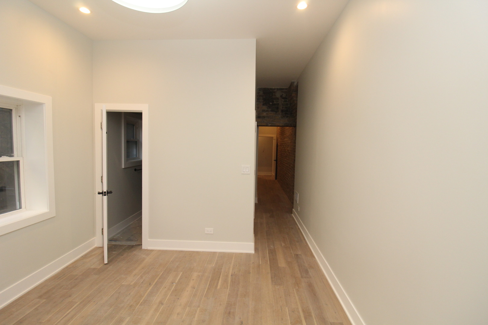 64 East Cedar Street, Unit 2R Chicago, IL 60611 - Photo 16 of 17 an empty room with wooden floor and windows