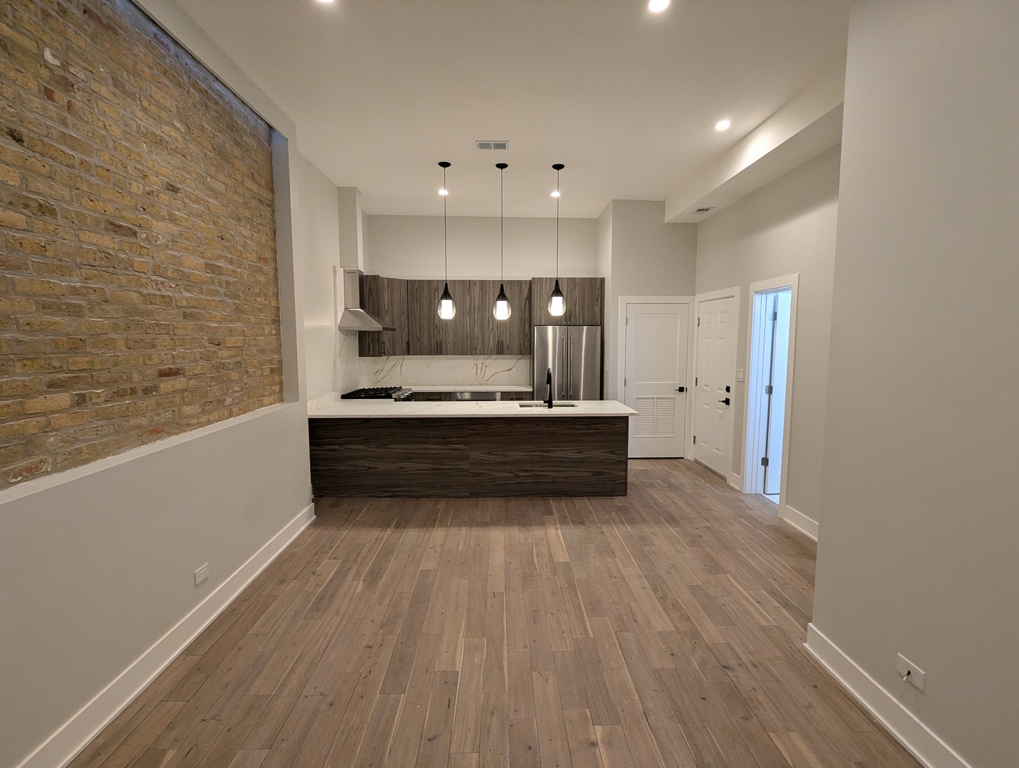64 East Cedar Street, Unit 2R Chicago, IL 60611 - Photo 3 of 17 a view of a kitchen with kitchen island a sink wooden floor and stainless steel appliances