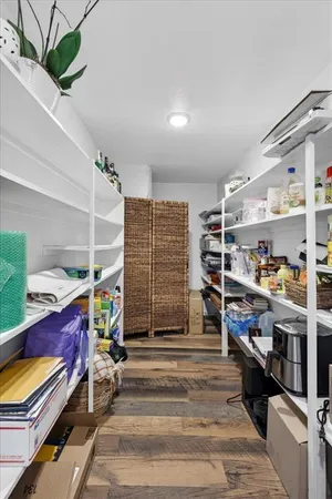 a storage room with stainless steel appliances kitchen island granite countertop a refrigerator and a counter top space