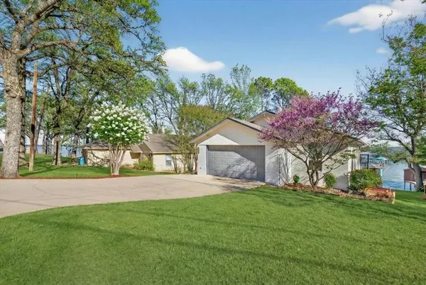 a front view of a house with a yard and trees