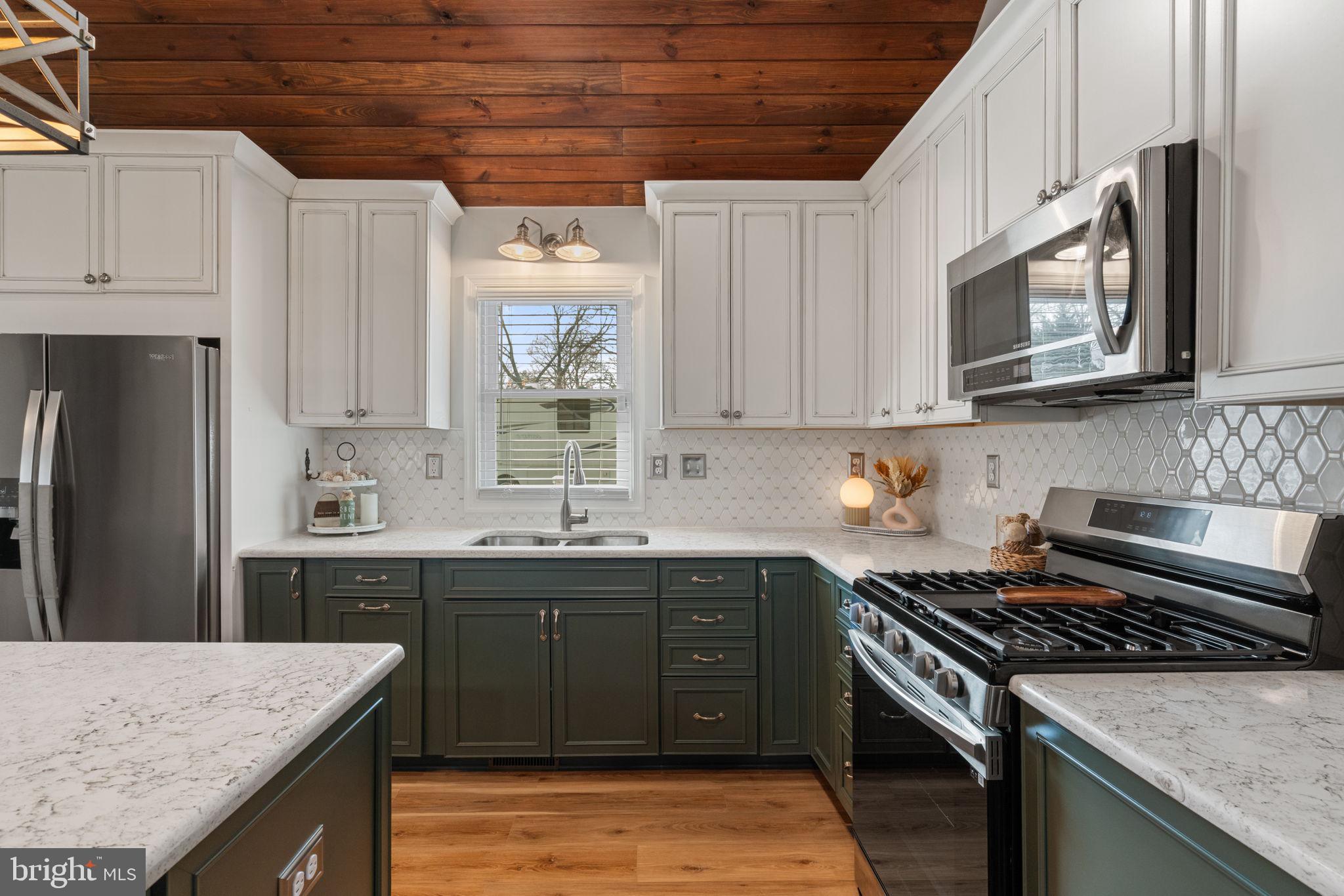 37 Pendleton Road Fredericksburg, VA 22405 - Photo 14 of 43 a kitchen with stainless steel appliances granite countertop a stove a sink dishwasher and a microwave oven with wooden cabinets