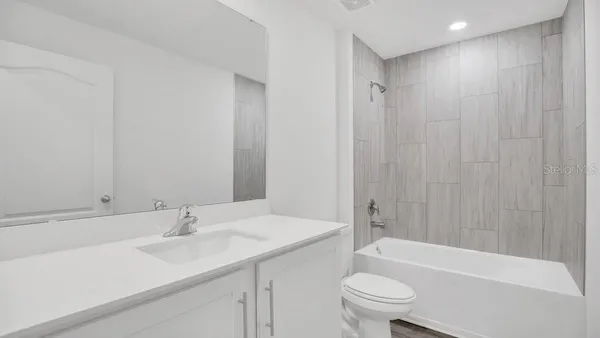 a bathroom with a sink a toilet and a large mirror