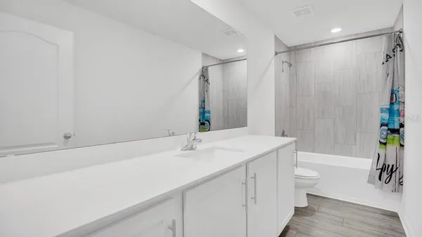 a bathroom with a sink a toilet a tub and shower