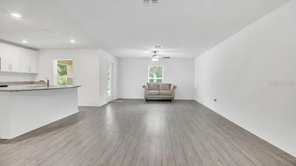 a view of a kitchen with furniture and wooden floor