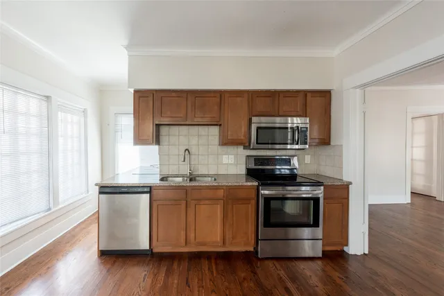 a kitchen with stainless steel appliances a stove a sink and a microwave