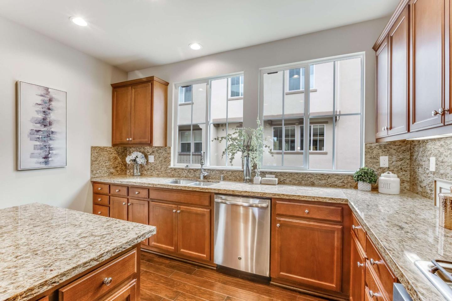 579 Holthouse Terrace Sunnyvale, CA 94087 - Photo 14 of 37 a kitchen with stainless steel appliances granite countertop wooden cabinets and a granite counter tops with a large window