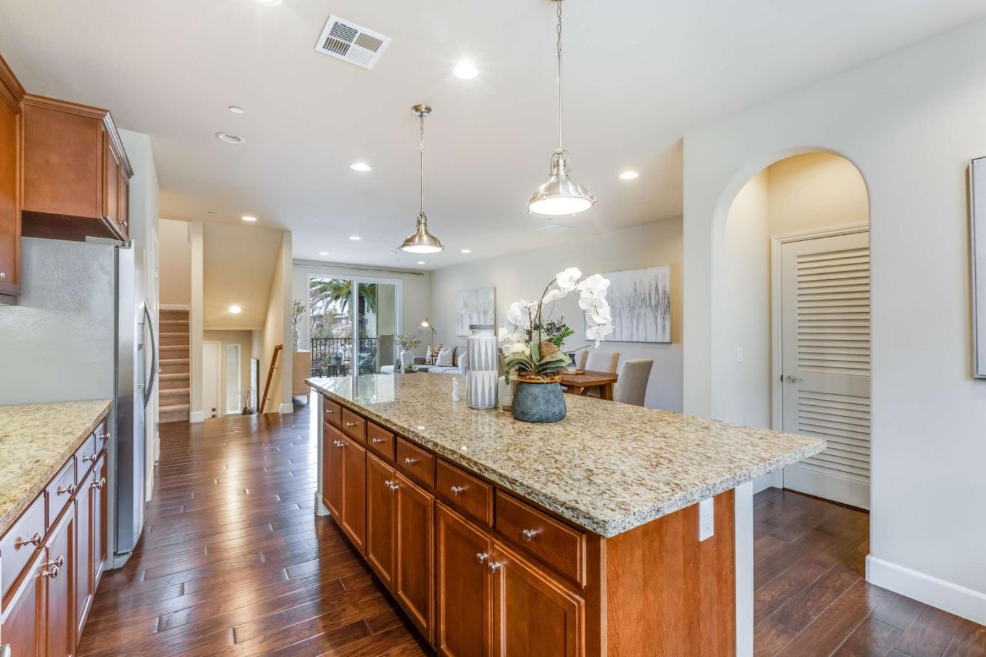579 Holthouse Terrace Sunnyvale, CA 94087 - Photo 15 of 37 a kitchen with center island wooden floor stainless steel appliances and living room view