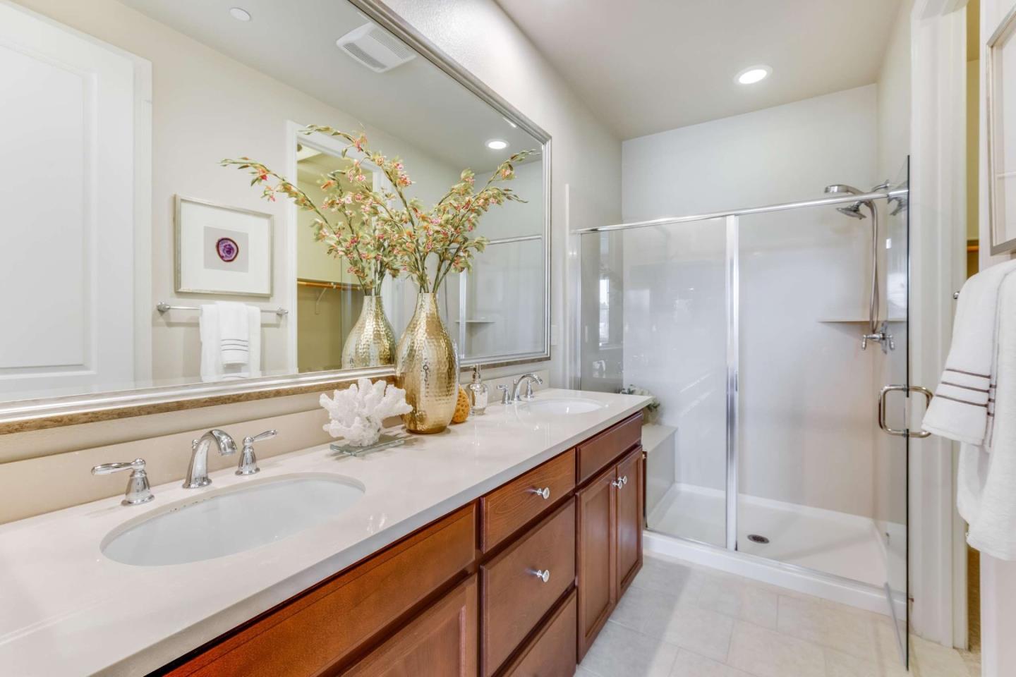 579 Holthouse Terrace Sunnyvale, CA 94087 - Photo 20 of 37 a bathroom with a granite countertop sink a shower and a mirror