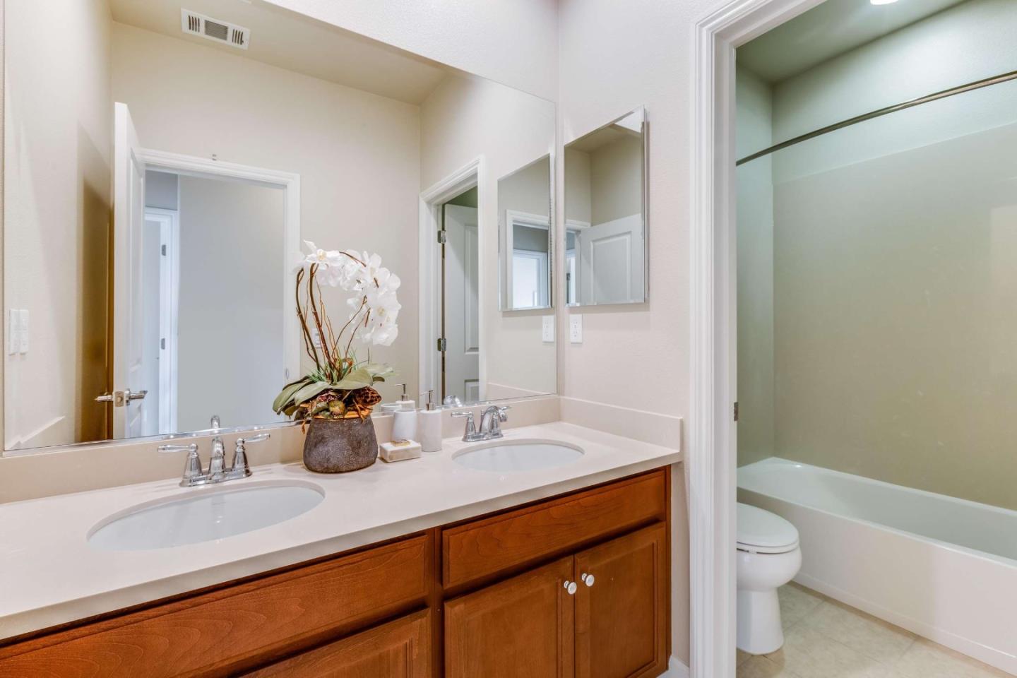 579 Holthouse Terrace Sunnyvale, CA 94087 - Photo 24 of 37 a bathroom with a double vanity sink toilet and a mirror