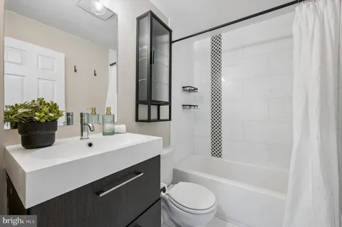 a bathroom with a sink toilet a mirror and shower