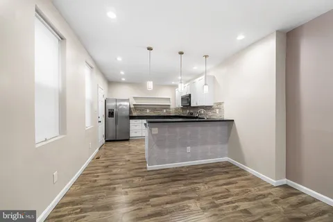 a view of hallway with stairs and wooden floor