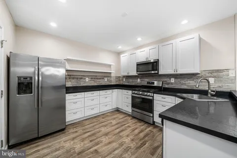 a kitchen with granite countertop a sink and steel appliances