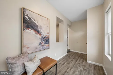 a view of a hallway with furniture and wooden floor
