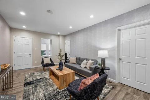 a living room with furniture and a wooden floor