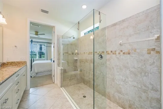 a spacious bathroom with a granite countertop sink a shower a mirror and a shower