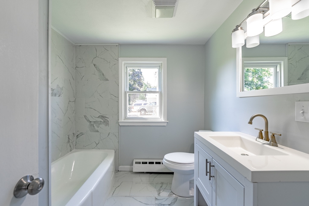 126 Lancaster Avenue West Springfield, MA 01089 - Photo 11 of 35 a bathroom with a sink a toilet a mirror a bathtub and shower