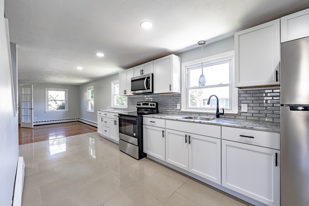 126 Lancaster Avenue West Springfield, MA 01089 - Photo 15 of 35 a kitchen with granite countertop a stove a sink and a refrigerator
