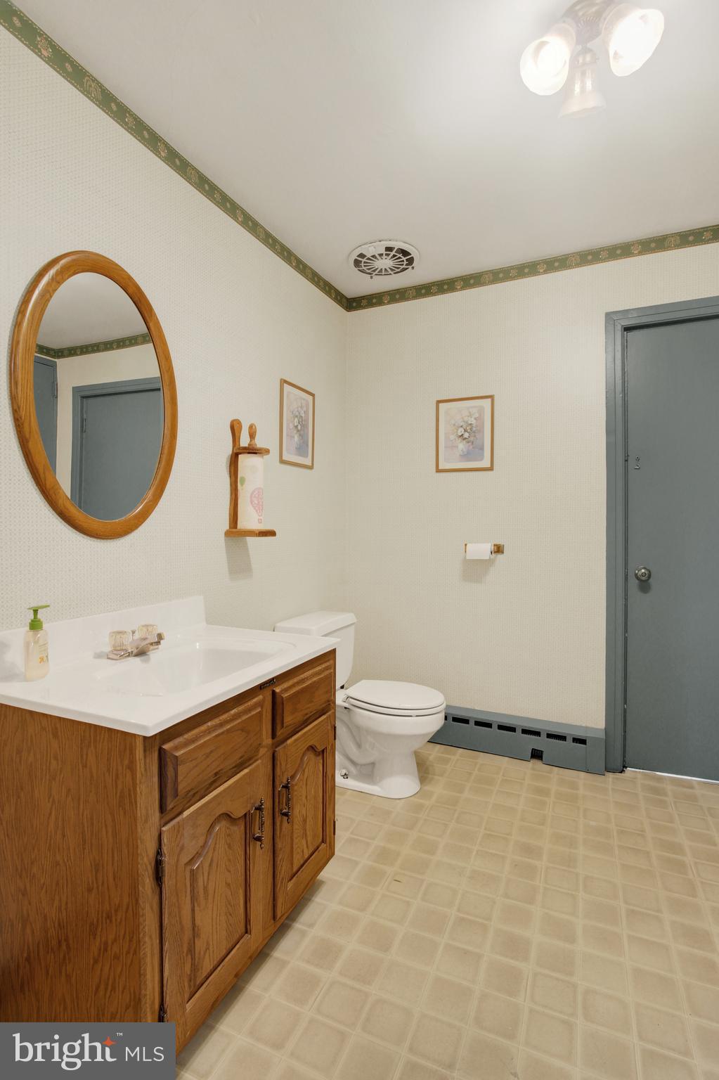 209 Broadway Hanover, PA 17331 - Photo 24 of 28 a bathroom with a toilet sink vanity and mirror