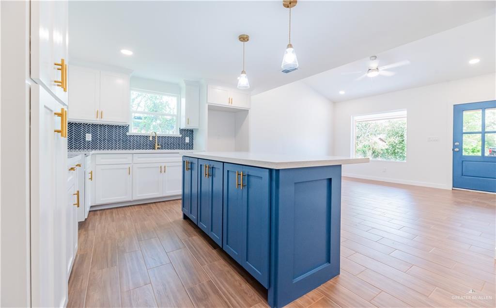 214 South 28th Street McAllen, TX 78501 - Photo 3 of 11 a kitchen with kitchen island wooden floors appliances and cabinets