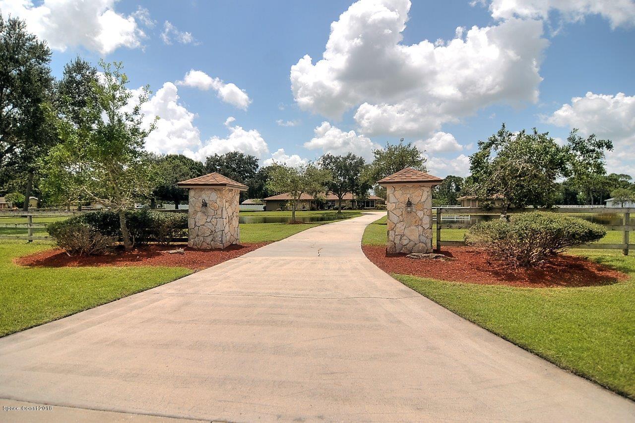 4107 Pinewood Road Melbourne, FL 32934 - Photo 2 of 32 a house view with swimming pool and trees in the background