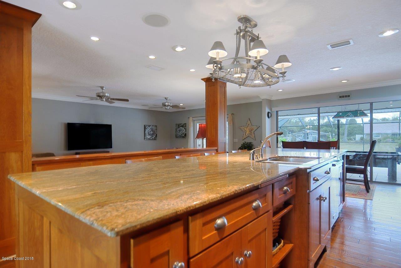 4107 Pinewood Road Melbourne, FL 32934 - Photo 17 of 32 a living room with stainless steel appliances kitchen island granite countertop furniture and fireplace
