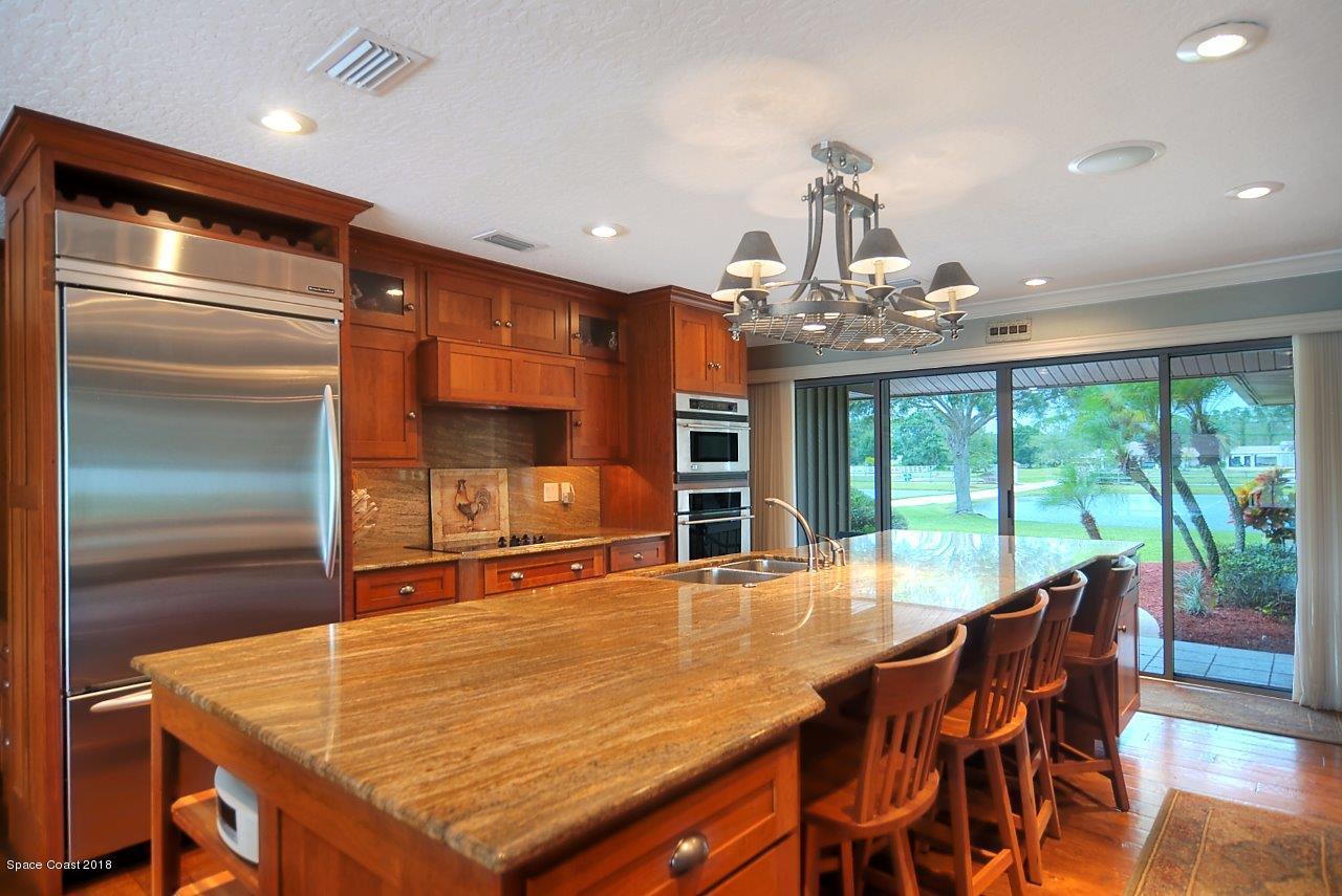 4107 Pinewood Road Melbourne, FL 32934 - Photo 18 of 32 a dining room with a table chairs and chandelier