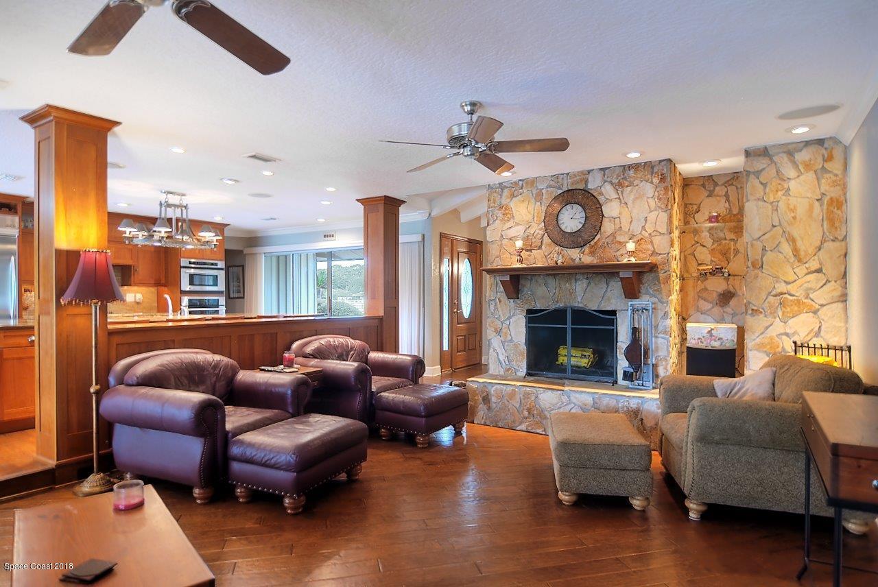 4107 Pinewood Road Melbourne, FL 32934 - Photo 20 of 32 a living room with furniture a fireplace and a large window