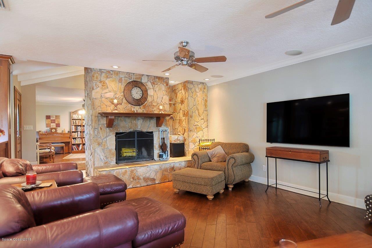 4107 Pinewood Road Melbourne, FL 32934 - Photo 21 of 32 a living room with furniture a flat screen tv and a fireplace