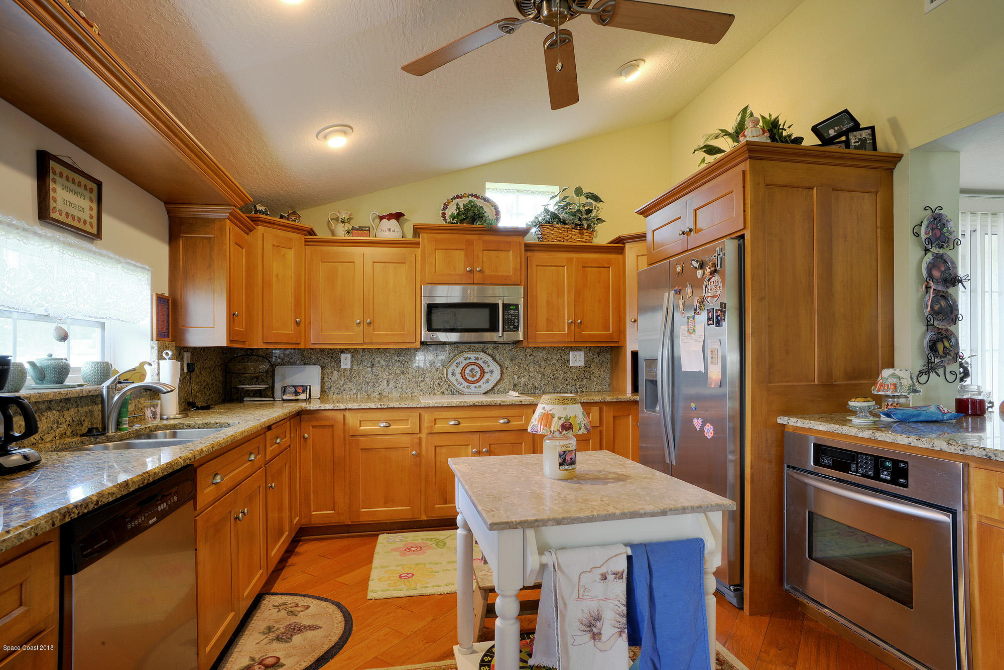 4107 Pinewood Road Melbourne, FL 32934 - Photo 26 of 32 a kitchen with stainless steel appliances granite countertop a sink a stove and a refrigerator