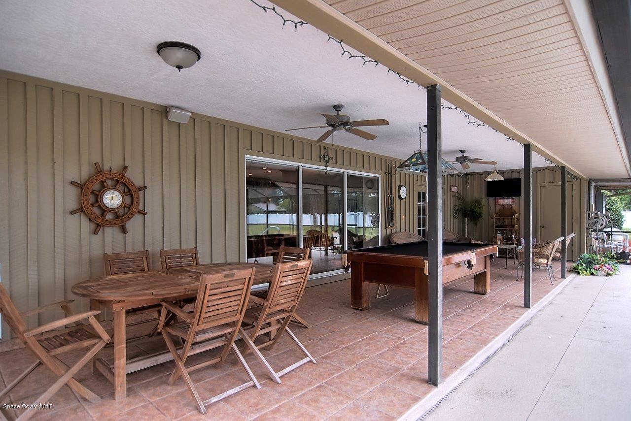 4107 Pinewood Road Melbourne, FL 32934 - Photo 7 of 32 a view of a patio with a dining table and chairs